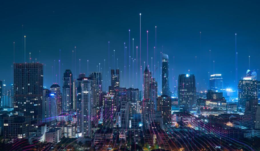 Nighttime city skyline with bright light lines in the sky